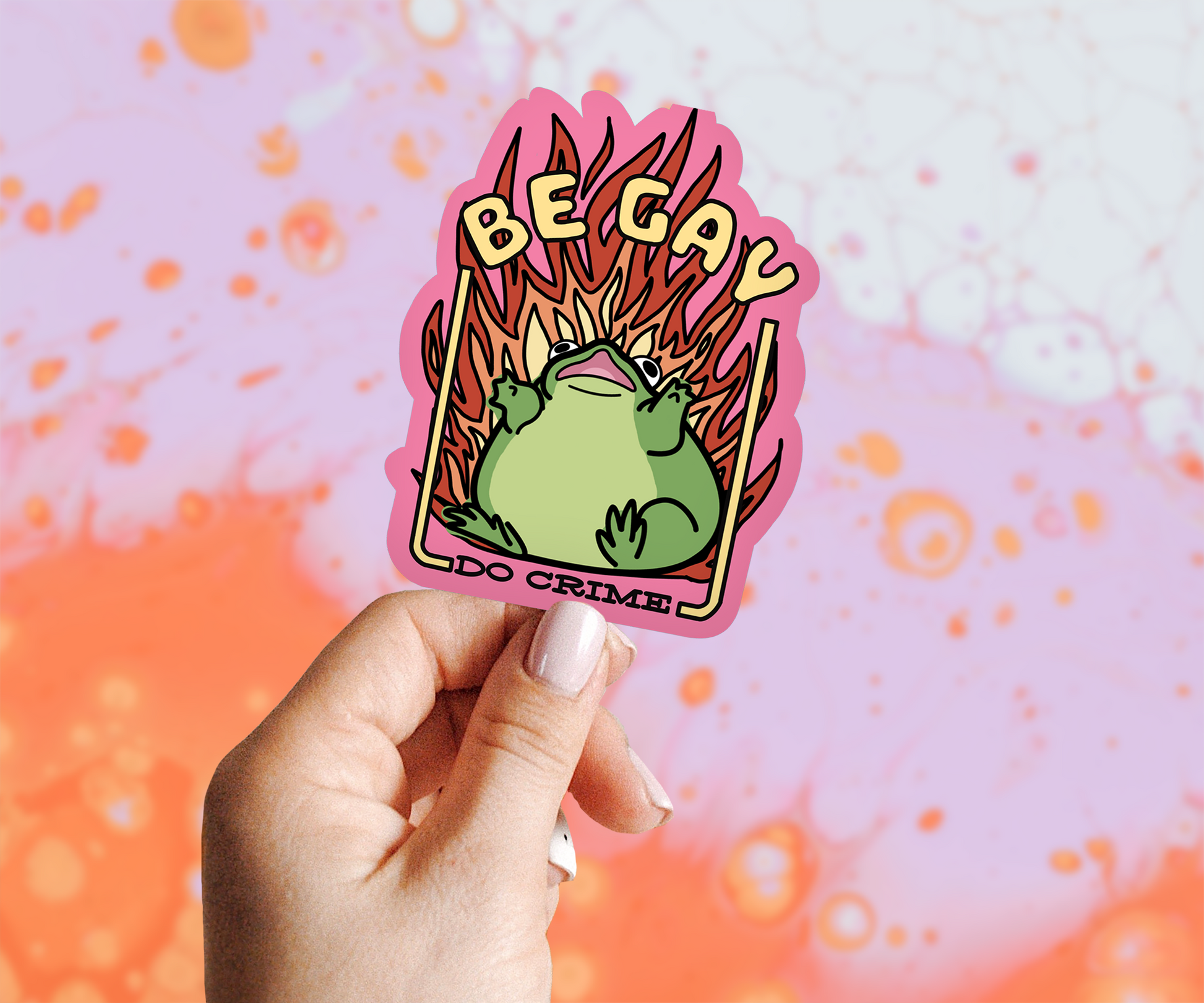 Pink Sticker Says: Be Gay Do Crime and has a Panicking Frog with Fire Behind Him